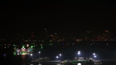 Pattaya Körfezi 'nde yüzen restoran ve balıkçı tekneleri Pattaya şehrinin gece ışıkları altında turistleri bekliyor.