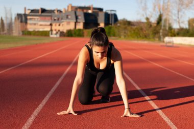 young sportsman on the running track doing stretching and exercises