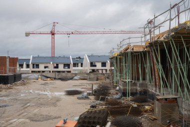 Construction area. Buildings half built and a crane in the background