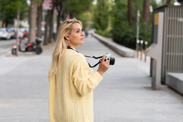 Blondýny Žena Drží Fotoaparát Při Chůzi Rozptýlené Ulici — Stock fotografie