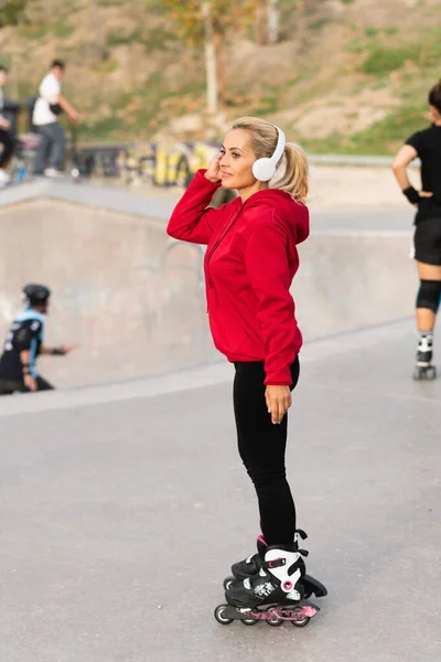 Вертикальна Фотографія Блондинки Дорослої Жінки Вбудованими Ковзанами Навушниками Стоять Парку — стокове фото