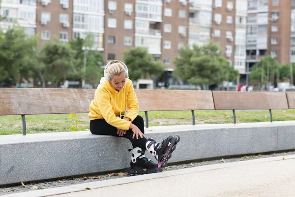 Blonde Caucasian Woman Listening Music While Looking His Inline Skates — Fotografia de Stock