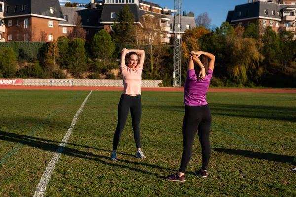 Two Young Women Doing Stretching Grass Running Track Playing Sports — Fotografia de Stock