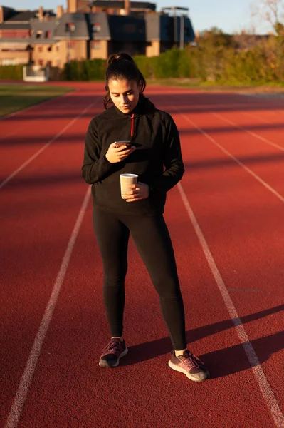Young Athlete Looks Mobile While Having Coffee Running Track — Foto de Stock