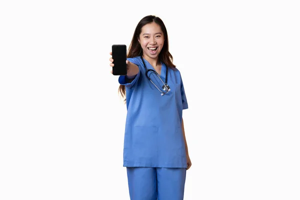Studio Fotografie Bílým Pozadím Asijského Lékaře Zobrazující Mobil Veselým Výrazem Stock Fotografie