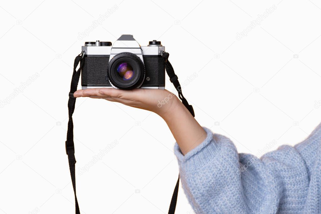Studio shoot of the hand of a woman holding a digital camera with a white background