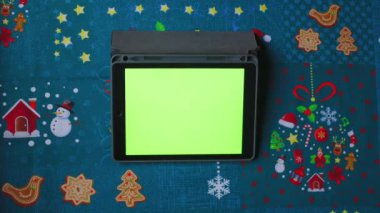 Yeşil Ekranlı Dijital Tablet. Yeşil tablet üst görünümü. Noel Tatili Konsepti. Model yap. Noel masasında yeşil ekranlı tablet.