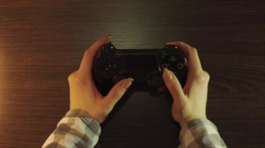 Kanepede oturan ve konsolda video oyunları kazanan güzel heyecanlı genç bayan oyuncu. Kablosuz bir denetleyici ile oynar