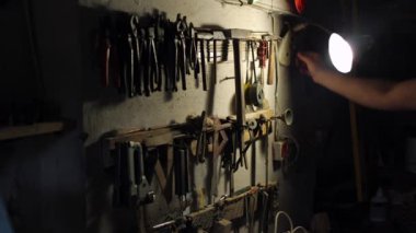 Garajda eski bir alet var, adam işe gidiyor, aletini eline alıyor.