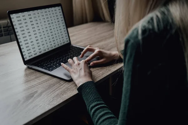 Las manos de una mujer joven están escribiendo en un portátil. Trabajo en el espacio de trabajo en casa. Estudiante. Negocios en línea y freelancing. Enseñanza a distancia. Trabajar con números y texto. — Foto de Stock