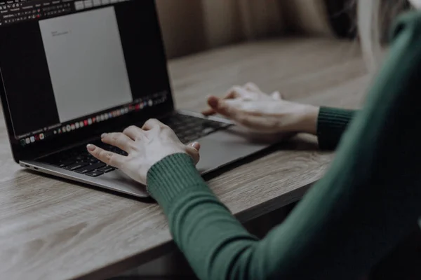 Las manos de una mujer joven están escribiendo en un portátil. Trabajo en el espacio de trabajo en casa. Estudiante. Negocios en línea y freelancing. Enseñanza a distancia. Trabajar con números y texto. — Foto de Stock