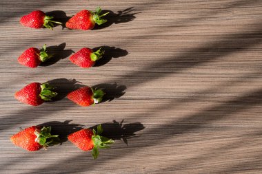 Kırmızı, taze ve olgun çilekli metin için ahşap arka plan. Böğürtlenlerin yaz süslemesi