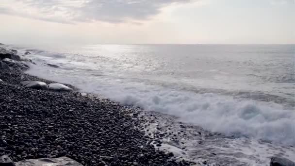 Costa di mare con spiaggia di ghiaia in tempo ventoso con onde, spruzzi e schiuma. Bellissimo paesaggio alla luce del sole. Mar Nero. — Video Stock