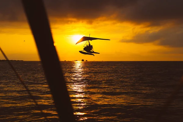 An hang glider flies over the sea at sunset. Summer activities. Sport. — Stock Photo, Image