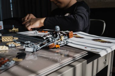 21.03.2022. Batumi, Georgia. Çocuk, Lego inşaatçısını Yıldız Savaşları masasında elle katlıyor. Disney