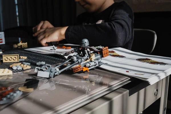 21.03.2022. Batumi, Georgia. Çocuk, Lego inşaatçısını Yıldız Savaşları masasında elle katlıyor. Disney