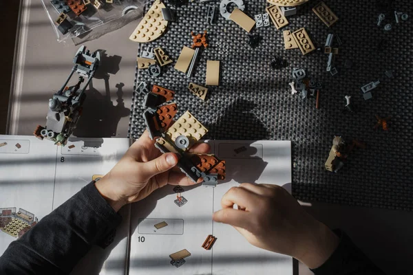 21.03.2022. Batumi, Georgia. Çocuk, Lego inşaatçısını elle masaya yatırıyor. Üst Manzara. Yıldız Savaşları. Disney