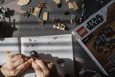21.03.2022. Batumi, Georgia. Çocuk, Lego inşaatçısını elle masaya yatırıyor. Üst Manzara. Yıldız Savaşları. Disney