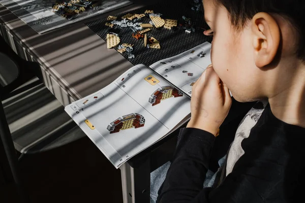 21.03.2022. Batumi, Georgia. Çocuk, Lego inşaatçısını Yıldız Savaşları masasında elle katlıyor. Disney