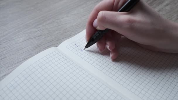 Une femme écrit des chiffres et numérote de 1 à 10 avec un stylo dans un carnet. Organisateur. Liste des choses à faire — Video
