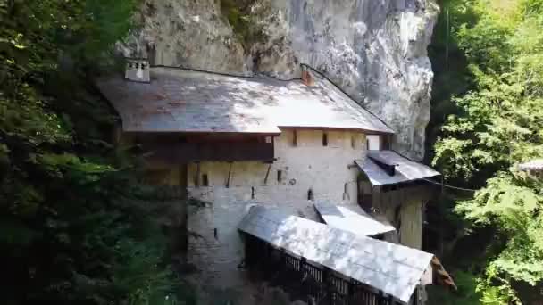 02石造りの川の上の洞窟にある古い教会と木製の橋 — ストック動画