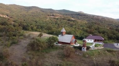 07, tepede güzel ahşap bir kilise. Üzerinde salıncaklar olan ahşap bir kule var ve insanlar yeşil çayırı seviyor.