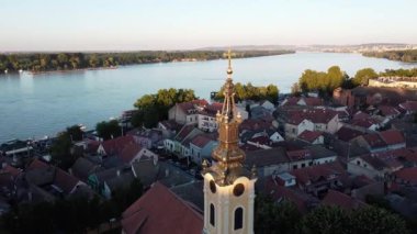 Güneşli bir günde şehrin 26 güzel manzarası. Nehir kıyısında başka bir nehre akan bir kilise var.