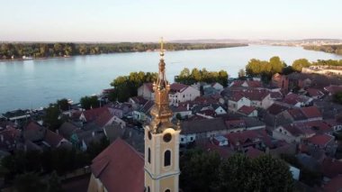 Güneşli bir günde şehrin 30 güzel manzarası. Nehir kıyısında başka bir nehre akan bir kilise.