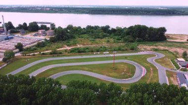 Şehirden uzakta nehir kenarındaki karting yolunun 4 hava görüntüsü.