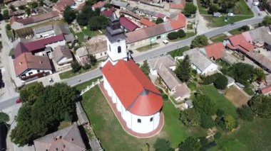 2 büyük beyaz kubbeli bir köy kilisesi ve ortasında haç olan bir saat.