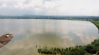 Şehrin yakınında terk edilmiş bir eko çiftliğinin olduğu büyük bir göl manzarası.