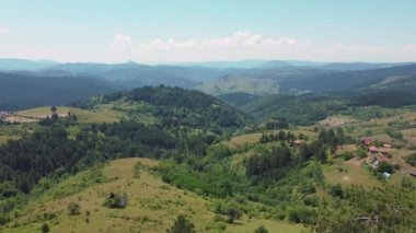Güneşli bir yaz gününde, tepelerin ve dağların güzel manzarasına aşık çiftler için bir bank.