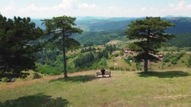 Güneşli bir yaz gününde tepelerin ve dağların güzel manzarasına aşık çiftler için bir bank.