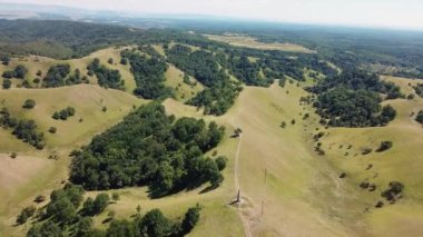 İnsanların yürüyüş yaptığı ve elektrikli bisiklete bindiği yeşil tepelerin muhteşem manzarası.