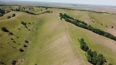 İnsanların yürüyüş yaptığı ve elektrikli bisiklete bindiği yeşil birbirine yakın tepelerin inanılmaz manzarası.