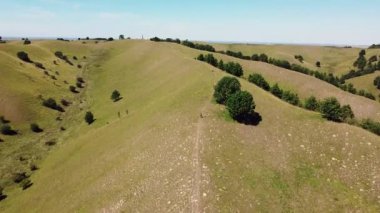 İnsanların yürüyüş yaptığı ve elektrikli bisiklet sürdüğü yeşil tepelerin inanılmaz manzarası.