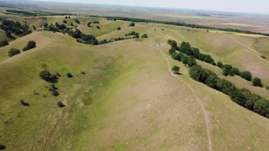 İnsanların yürüyüş yaptığı ve elektrikli bisiklete bindiği yeşil tepelerin muhteşem manzarası.
