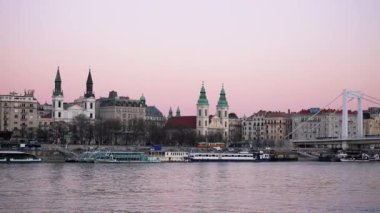 Nehir kıyısından, gemilerle ve köprüyle katedrallerin üzerindeki Budapeşte şehrinin manzarası