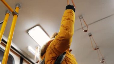 Bir kadın nakledilirken trenin içinde öğle yemeği tutuyor.