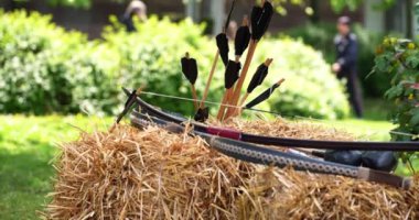 Dışarıda samanlığa yaslanmış bir ok ve yay.