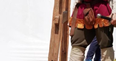 Elinde kılıçla ortaçağ savaşçısı kostümü giymiş bir asker.