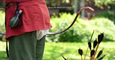 Ok, yay ve çeşitli ekipmanları olan bir asker.