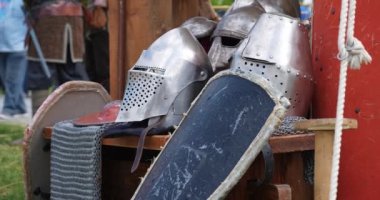 Koruyucu savaş teçhizatı çadıra dayanan birkaç miğfer ve kalkan.