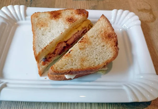 What a pleasant picture of two delicious sandwiches on a plate for a weary traveler after a tiring outdoor recreation.