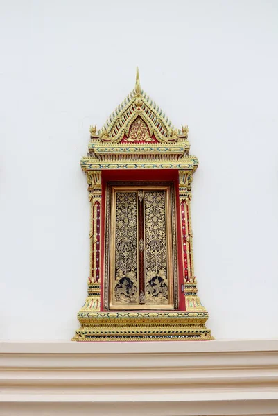 Bangkok, Tayland 'daki beyaz kilise duvarında antik Tayland tarzında altın ve kırmızı pencere.