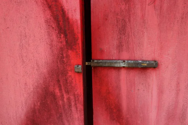 一种黑色生锈的门锁 用古铜制成 涂在漆成红色的木门上 — 图库照片