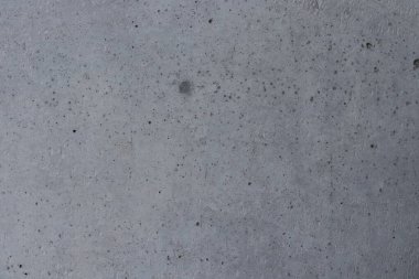 Yüzeyde gri beton ve koyu nokta, gri çimento arka plan.