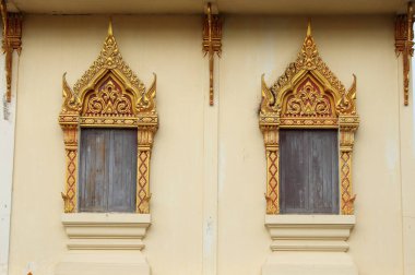 Tayland 'da Bangkok, Tayland' da açık sarı bir duvarda açık kahverengi duvarda bulunan gri ve kırmızı renkli ahşap çerçeveler..