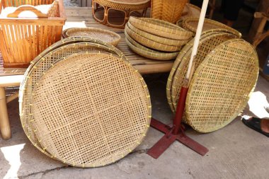 Pirinç kırma sepeti ya da harman sepetleri bambu masasının yanında, Tayland 'da başka bir bambu hasırı satışta..