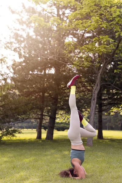 Gün doğumunda halka açık parkta yoga yapan güzel bir kadın.